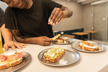 Woman preparing avocado toast on serving counter