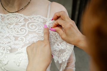 seamstress pinning a wedding dress on a mannequin