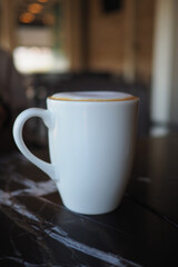 Warm mug of coffee on a table in a cozy cafe