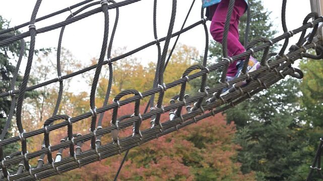 A cute brave little child enjoys her playtime on an outdoor playground. Defeating the fear of high
