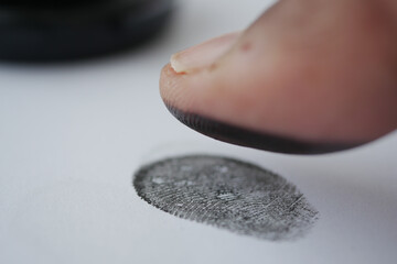 Fingerprint stamping on paper with a black ink pad