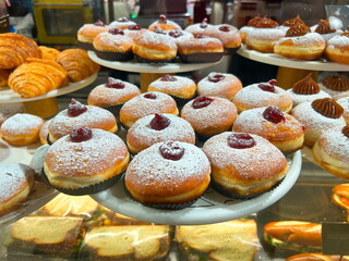 Sufganiyah - Hanukkah doughnuts on display at a coffee shop. Sufganiyot. Israeli holiday doughnuts.