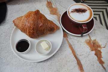 Morning coffee and croissant at a cozy cafe