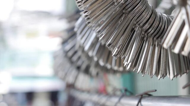 Bunch of blank metal key templates hanging in locksmith workshop reflecting light from nearby tools and workbench atmosphere. Handcrafted work.