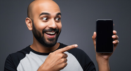A man in a blue t-shirt points at a blank smartphone screen, emphasizing modern digital connectivity and technology usage.