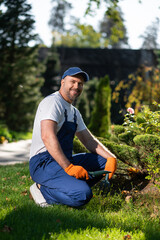 Man in uniform working with gardening tools during outdoor maintenance