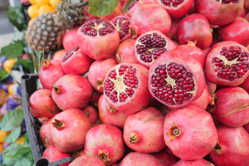 Pomegranates stacked at a vibrant farmers market in autumn