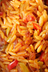 Orzo pasta dish with colorful vegetables and spices