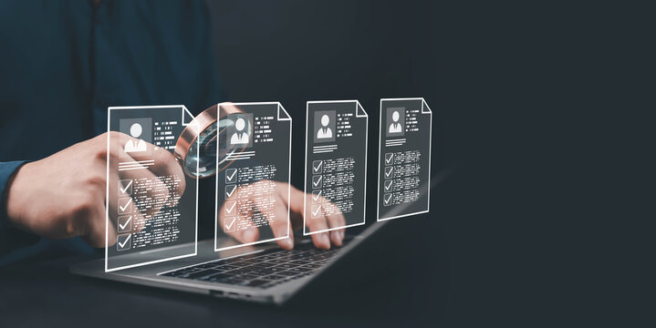 Businessman analyzing digital resumes on laptop with magnifying glass, representing recruitment, HR management, candidate evaluation, data analytics, and hiring technology concept.