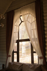 Warm sunlight coming through elegant window with soft curtains in cozy wellness resort lounge, creating relaxing and peaceful spa atmosphere.