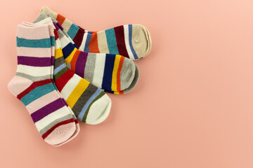 Bright striped socks for the cold seasons. A set of multicolored socks on a pink background.