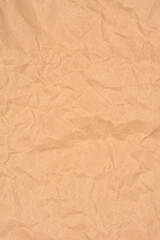 A vertical full-frame shot captures the wrinkled and crumpled texture of plain brown kraft paper, perfect for a rustic background