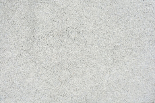 A full-frame, uniform close-up of a light gray suede or nubuck leather texture with a soft, slightly rough nap