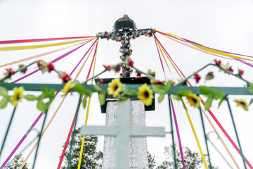 Catholic cross decorated with ribbons and flowers, Poland