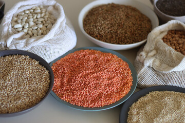 Bowls and bags full of various healthy grains and legumes. Selective focus.