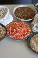 Bowls and bags full of various healthy grains and legumes. Selective focus.