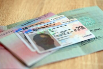 German Permanent resident card and document specimen lies on wooden table close up. Aufenthaltstitel and Fiktionsbescheinigung