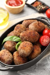 Tasty meat patties served on grey textured table, closeup