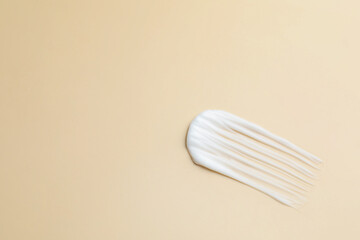 Sample of moisturizing cream on beige background, top view. Space for text