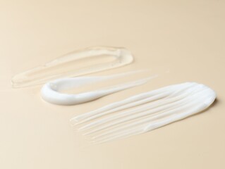 Samples of different cosmetic products on beige background, closeup