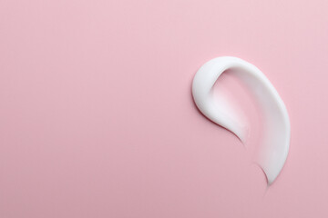 Sample of moisturizing cream on pink background, top view. Space for text