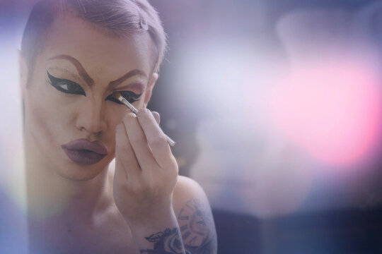 A drag queen actor puts on makeup