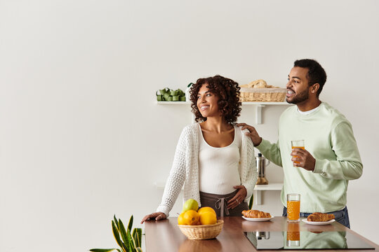 Joyful African American couple shares a moment at home while expecting their baby