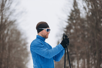 Male cross country skier preparing for activity in winter
