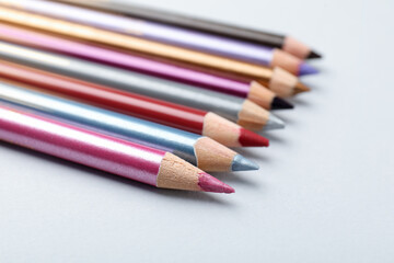 Different eye pencils on light background, closeup