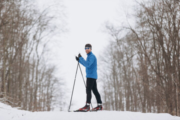 Man cross-country skiing on a snowy winter trail