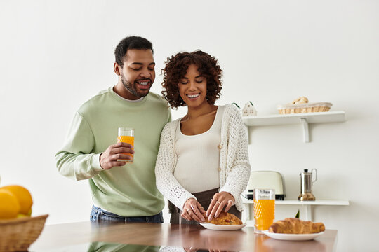 Joyful moments between expecting couple as they share breakfast at home