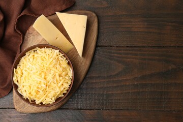 Grated and pieces of cheese on wooden table, top view. Space for text