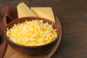 Grated and pieces of cheese on wooden table, closeup