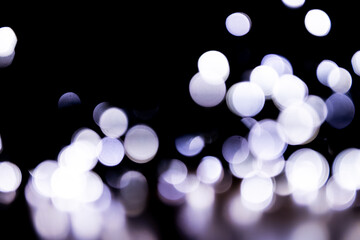 Abstract bokeh lights on a dark background. Christmas magical light, overlay or lens flare effect