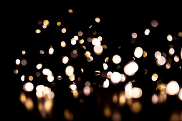 Abstract bokeh lights on a dark background. Christmas magical light, overlay or lens flare effect