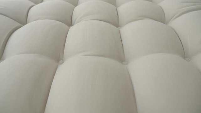 Close-up look at a soft white quilted fabric surface