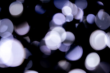 Abstract bokeh lights on a dark background. Christmas magical light, overlay or lens flare effect