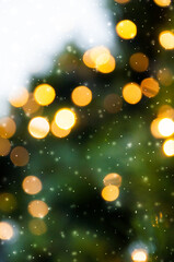 Golden bokeh lights on a dark background. Snowflakes falling down. Christmas magical light background, overlay or lens flare effect
