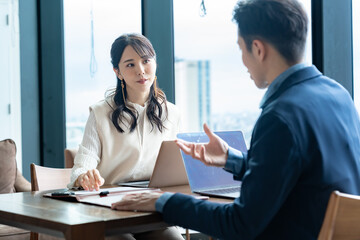 男女2人のビジネスパーソンが打ち合わせや商談をしている様