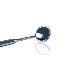 Dentist mirror reflecting light on a dark surface showing precision tool