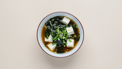 Wholesome Japanese miso soup with silken tofu, fresh seaweed, and green onions, served in a simple ceramic bowl, a traditional and authentic culinary delight