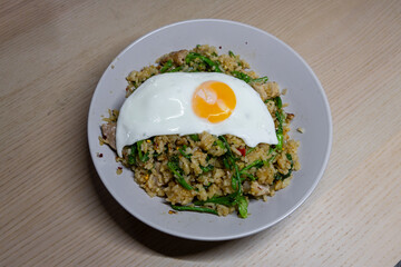 A plate of spicy fried rice with fried egg on top.