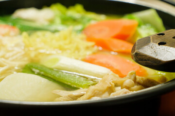 A hot pot dish simmered with vegetables like green onions, daikon radish, and carrots, along with crab and chicken—a famous winter delicacy in Japan.