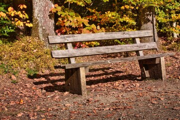 An old, rustic wooden and stone bench