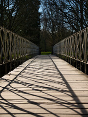 Fototapeta premium A pedestrian bridge crossing with planks and a steel fence