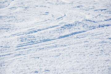 Close up of snowy surface displaying natural grooves and textures, capturing purity and tranquility of freshly fallen snow. Snowy background and winter theme.