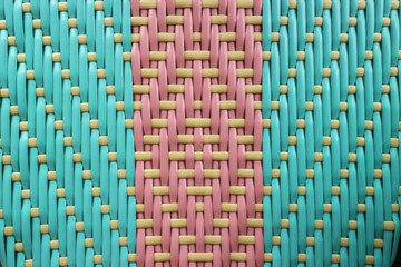 Close-up abstract grid texture of woven plastic in bright Blue, Pink, and Golden Yellow. A vibrant, geometric background with a contemporary pastel aesthetic, ideal for packaging design or branding.