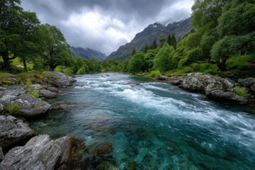 Flowing river surrounded by lush green trees and mountains in cloudy weather