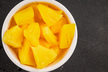 Pineapple canned chunks sweet fruit dessert tasty snack fresh delicious gourmet food background on the table rustic top view copy space keto and paleo diet vegetarian and vegan food