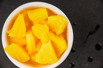Pineapple canned chunks sweet fruit dessert tasty snack fresh delicious gourmet food background on the table rustic top view copy space keto and paleo diet vegetarian and vegan food